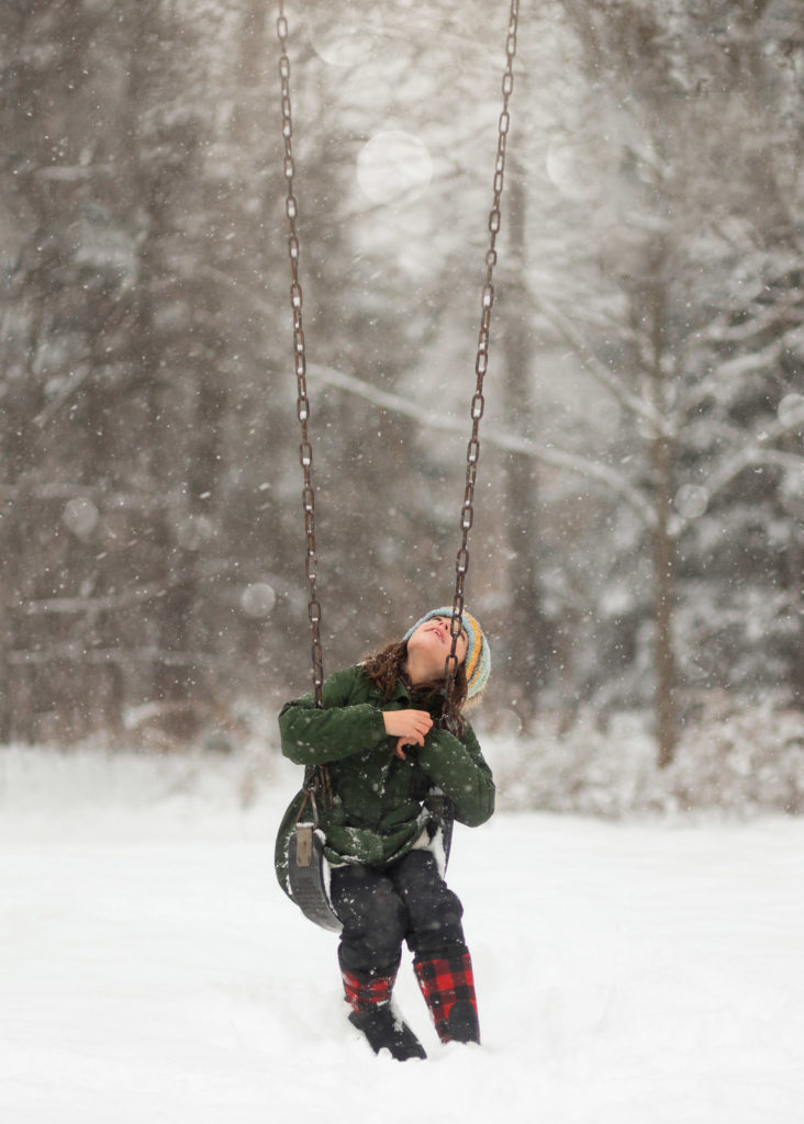 Girl on swing in the snow