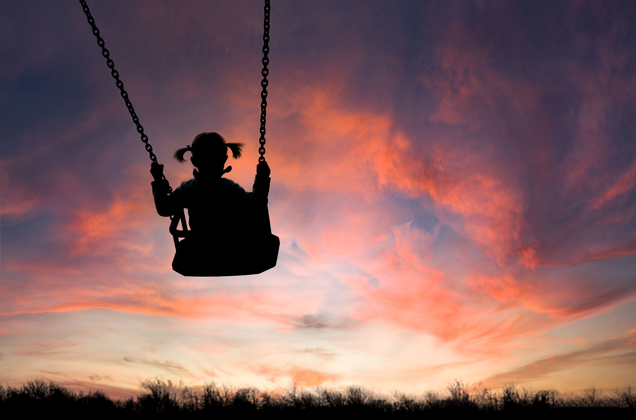 silhouette of girl on swing