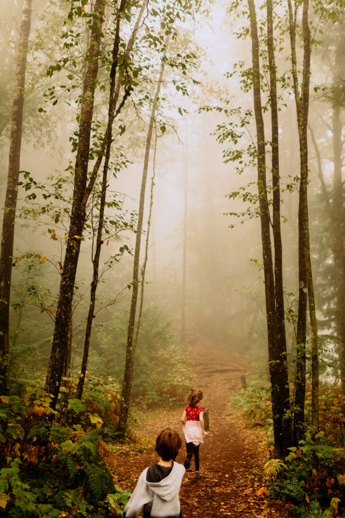 Children running through foggy forest