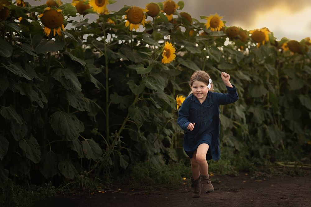 From backyard to dream location - girl running in the sunflowers