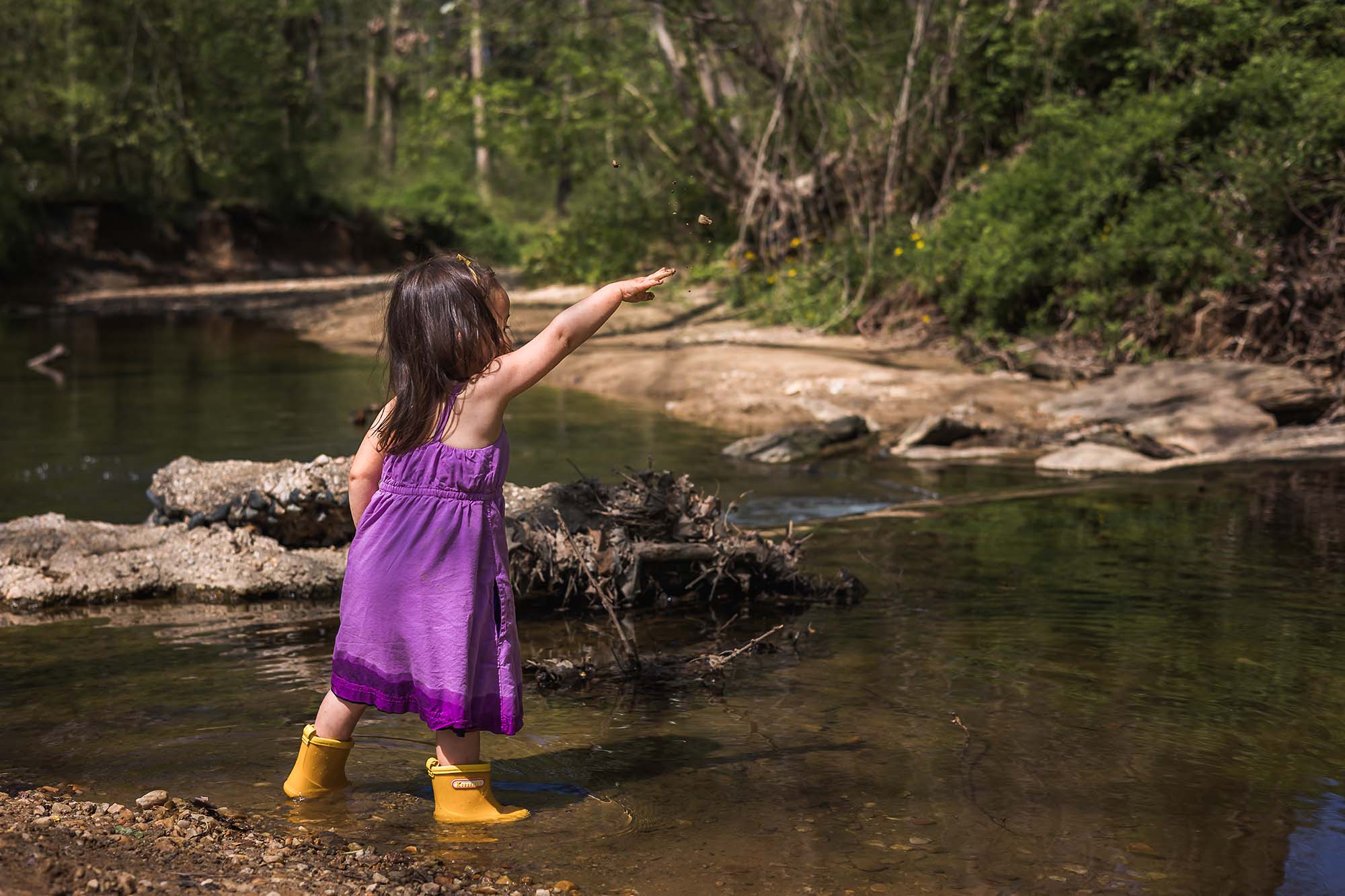 Girl throwing rocks in a stream