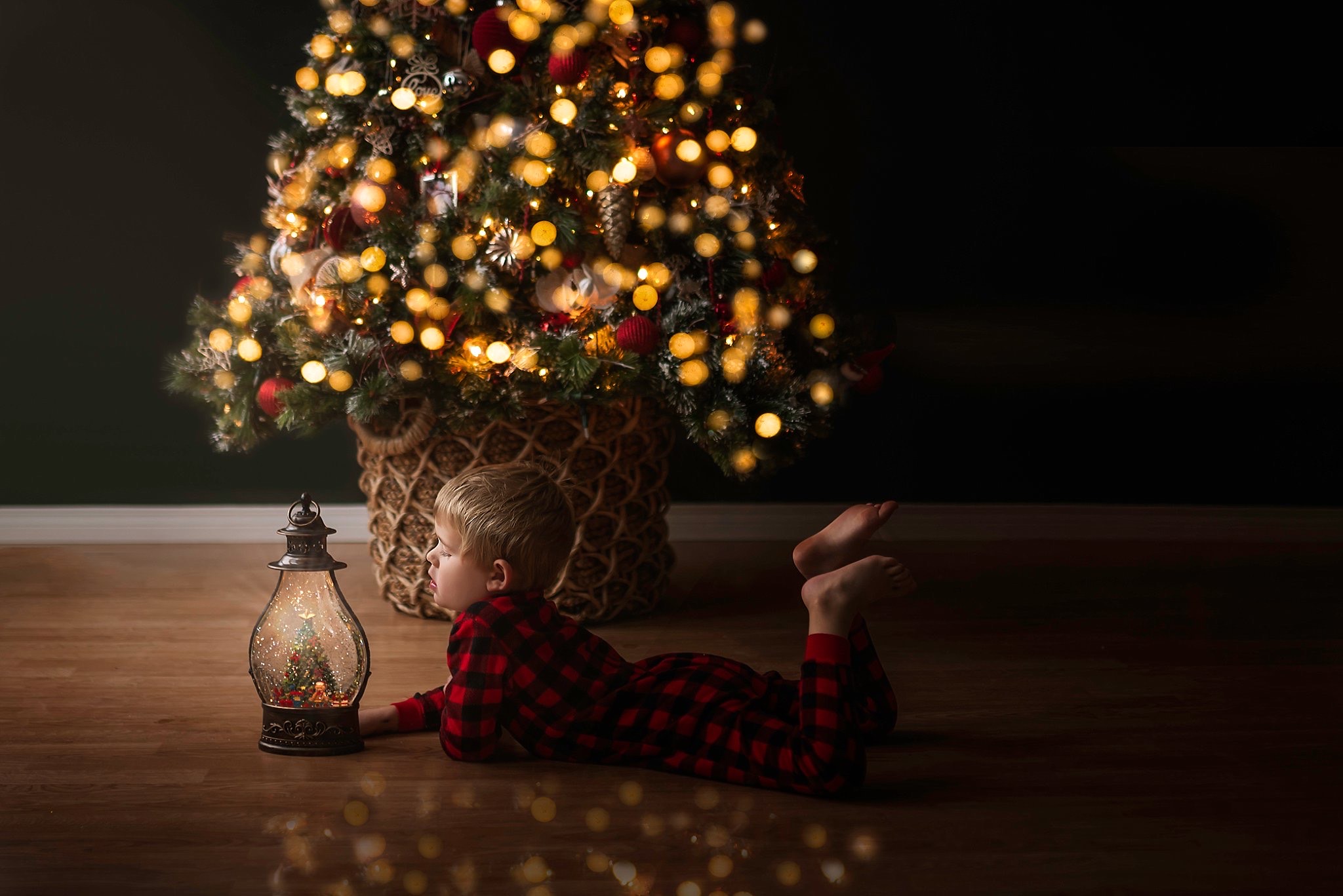 Boy on floor in front of a christmas tree