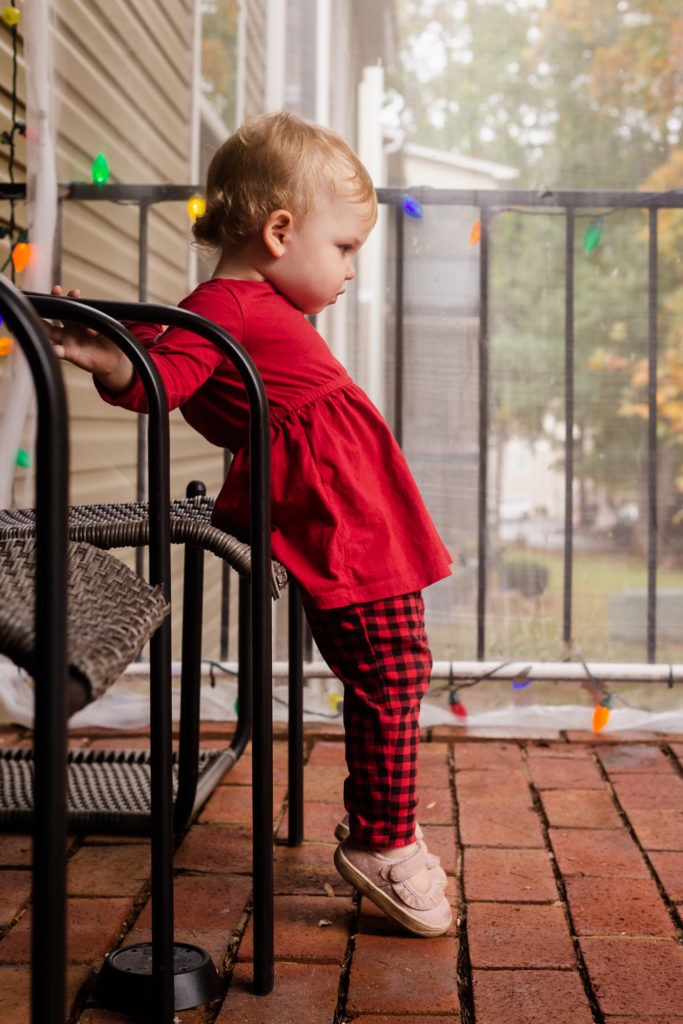 Child on porch with christmas lights