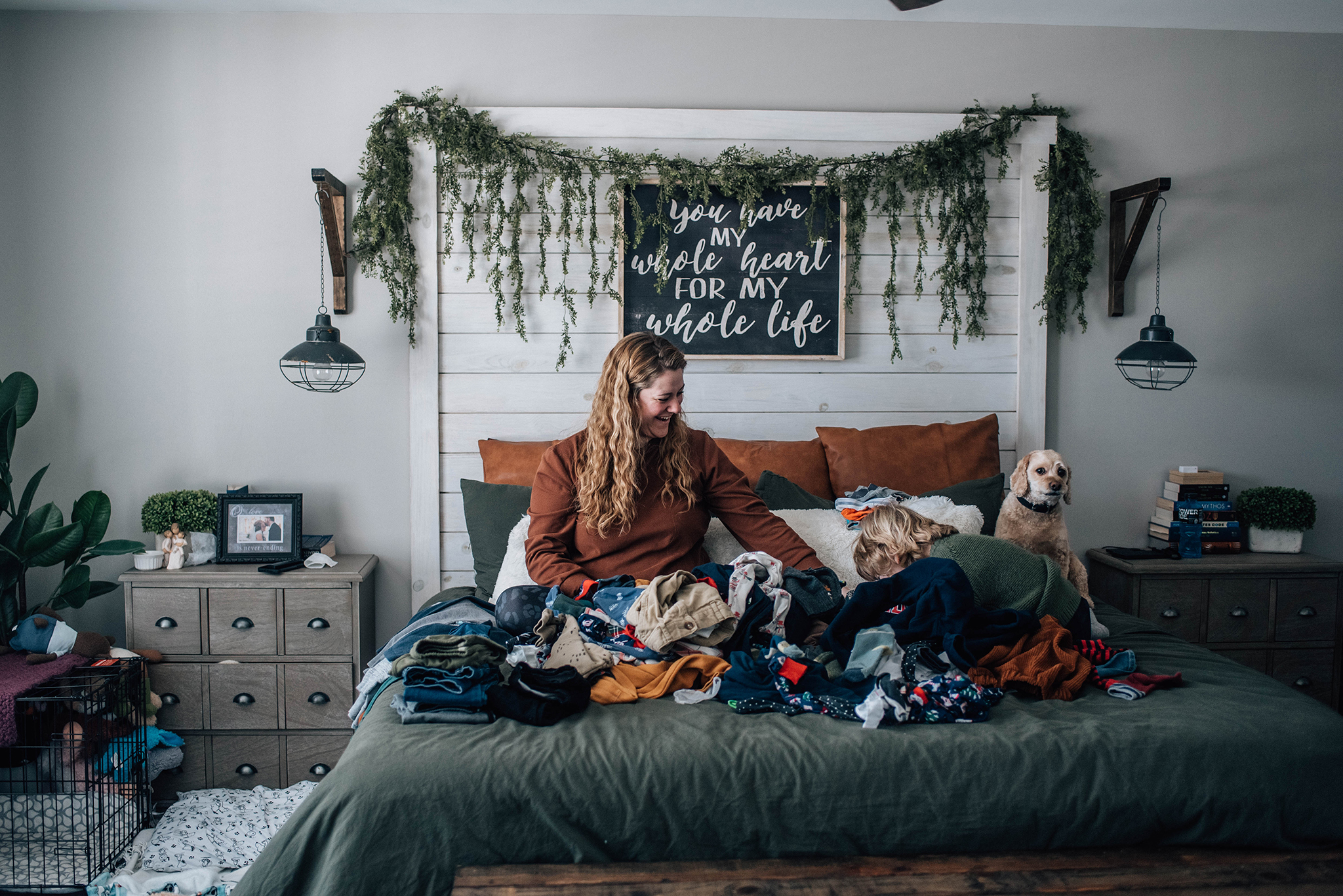 Unapologetically Us - Mom folding laundry on bed with child and dog