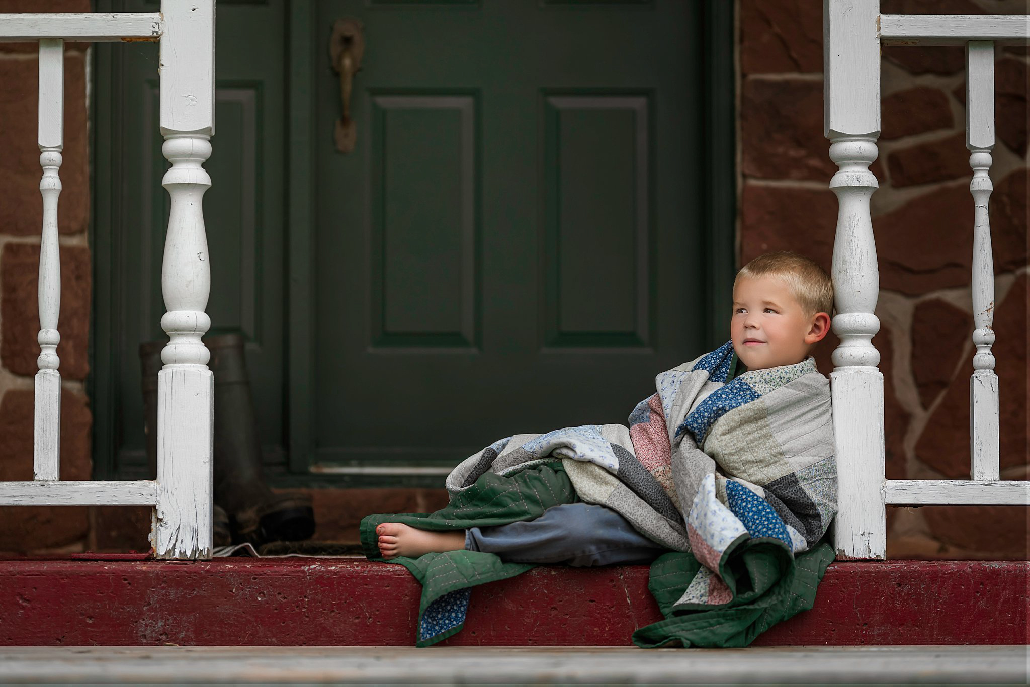 Developing Cozy, boy in blanket on porch