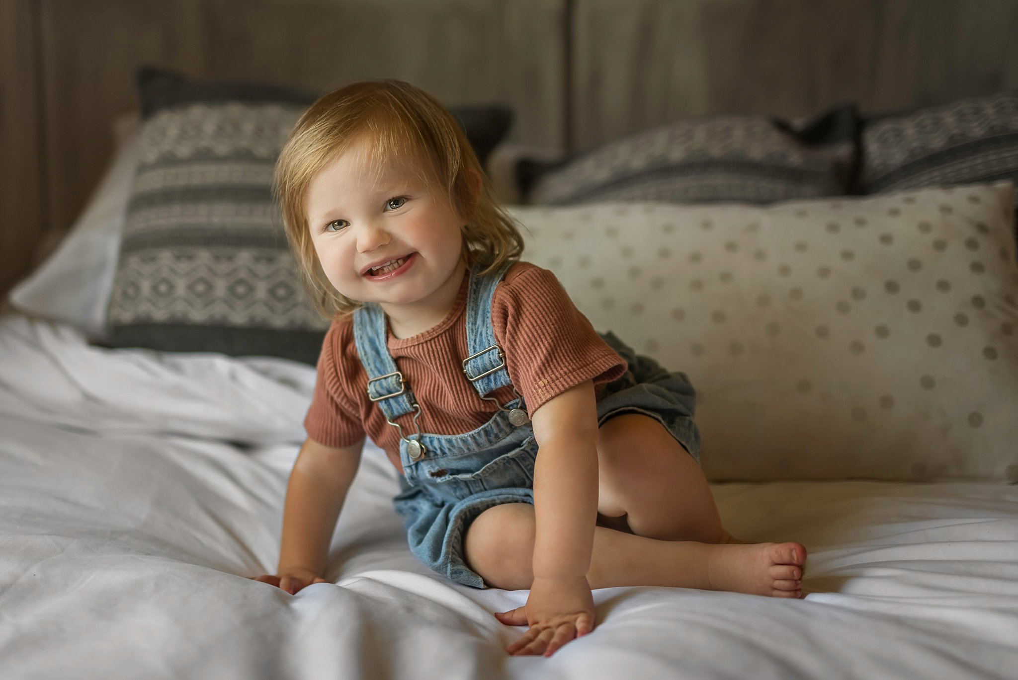 Little girl smiling on a bed