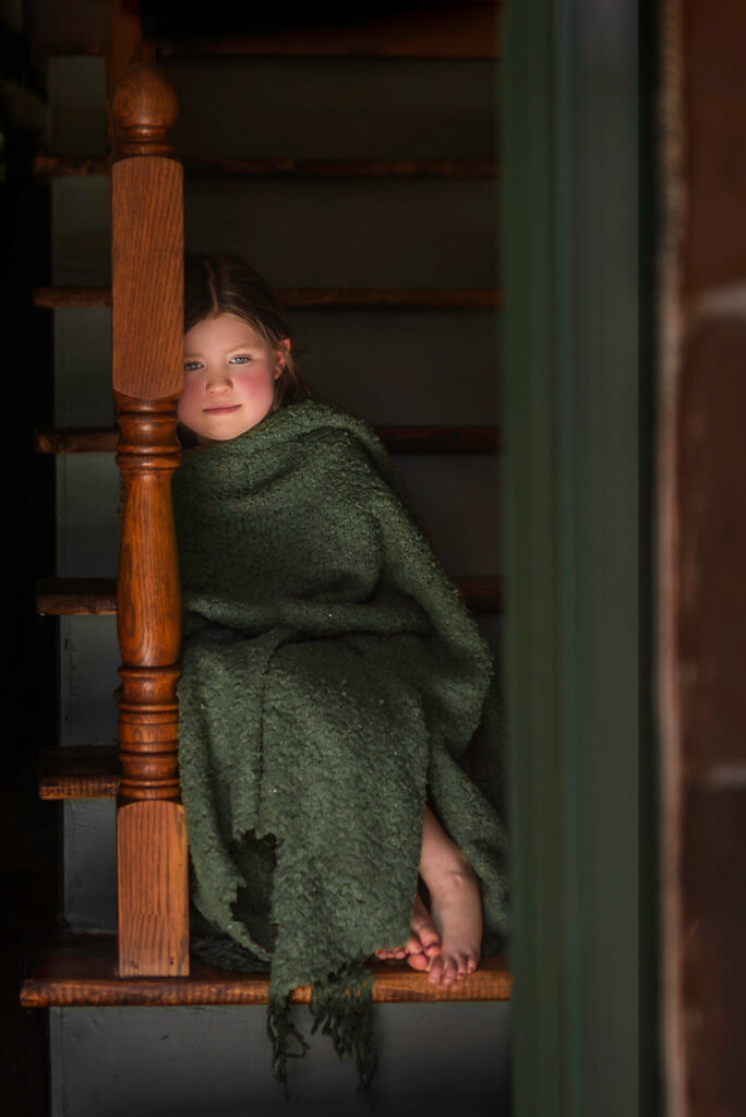 Developing Cozy girl in blanket on stairs