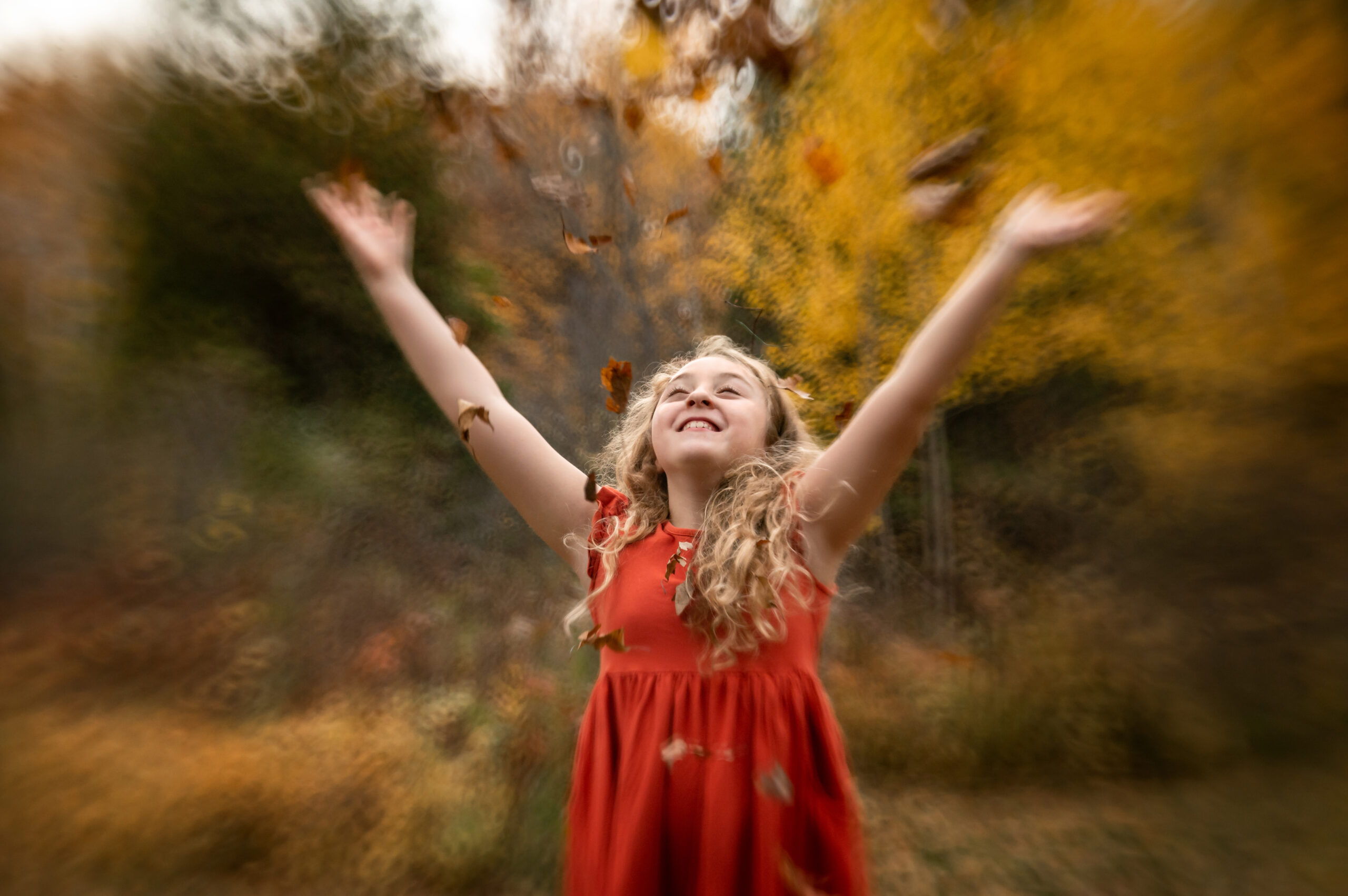 Girl throwing autumn leaves