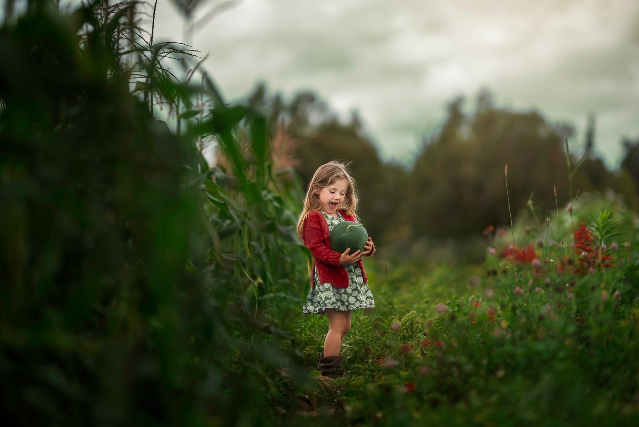 Little girl holding green pumpkin