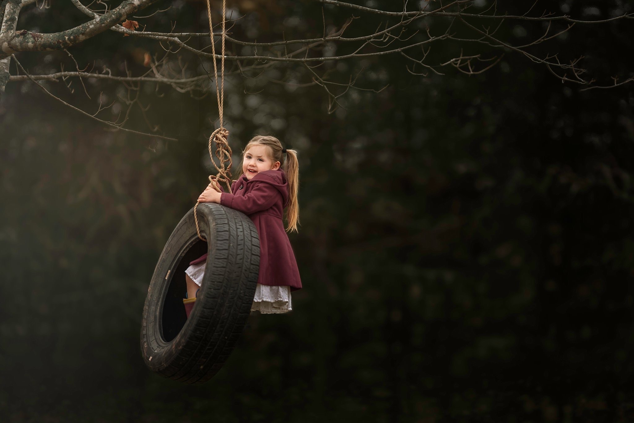 Little girl on tire swing