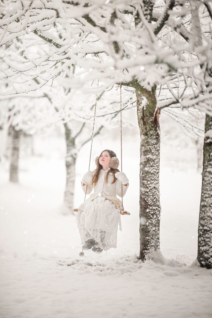 Creating a Nostalgic Childhood - girl on tree swing in the winter